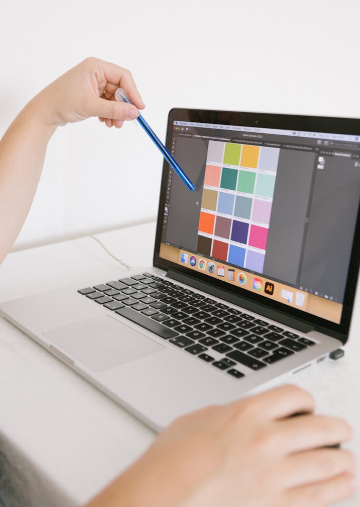 Close-up of hands using a laptop with a digital color palette, ideal for design work.